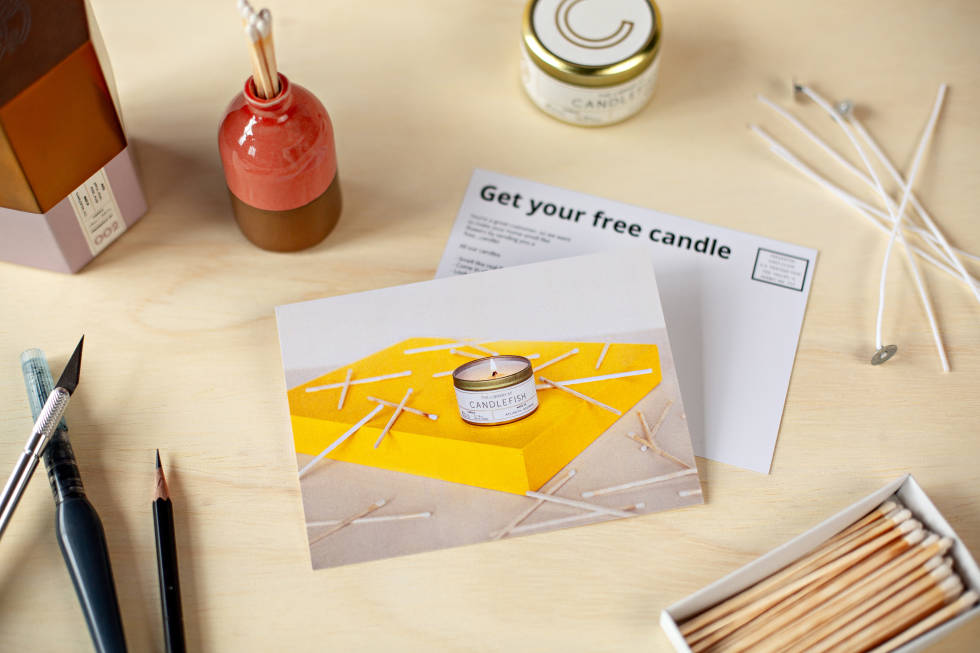 Postcards lying alongside a matchbox filled with matches and writing utensils